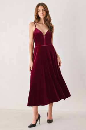 Woman wearing a sleeveless red burgundy velvet midi dress with a slight plunge | FREEMARKET