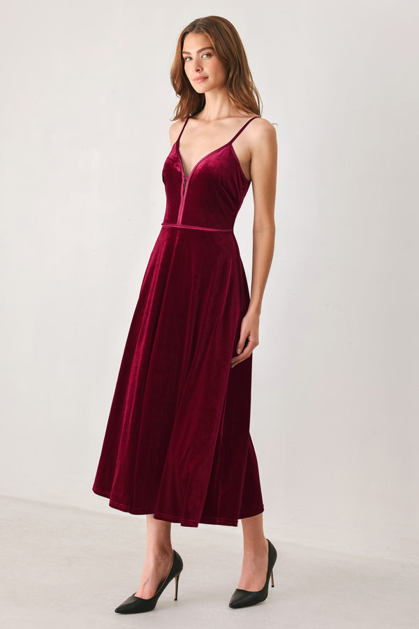 Woman wearing a sleeveless red burgundy velvet midi dress with a slight plunge | FREEMARKET
