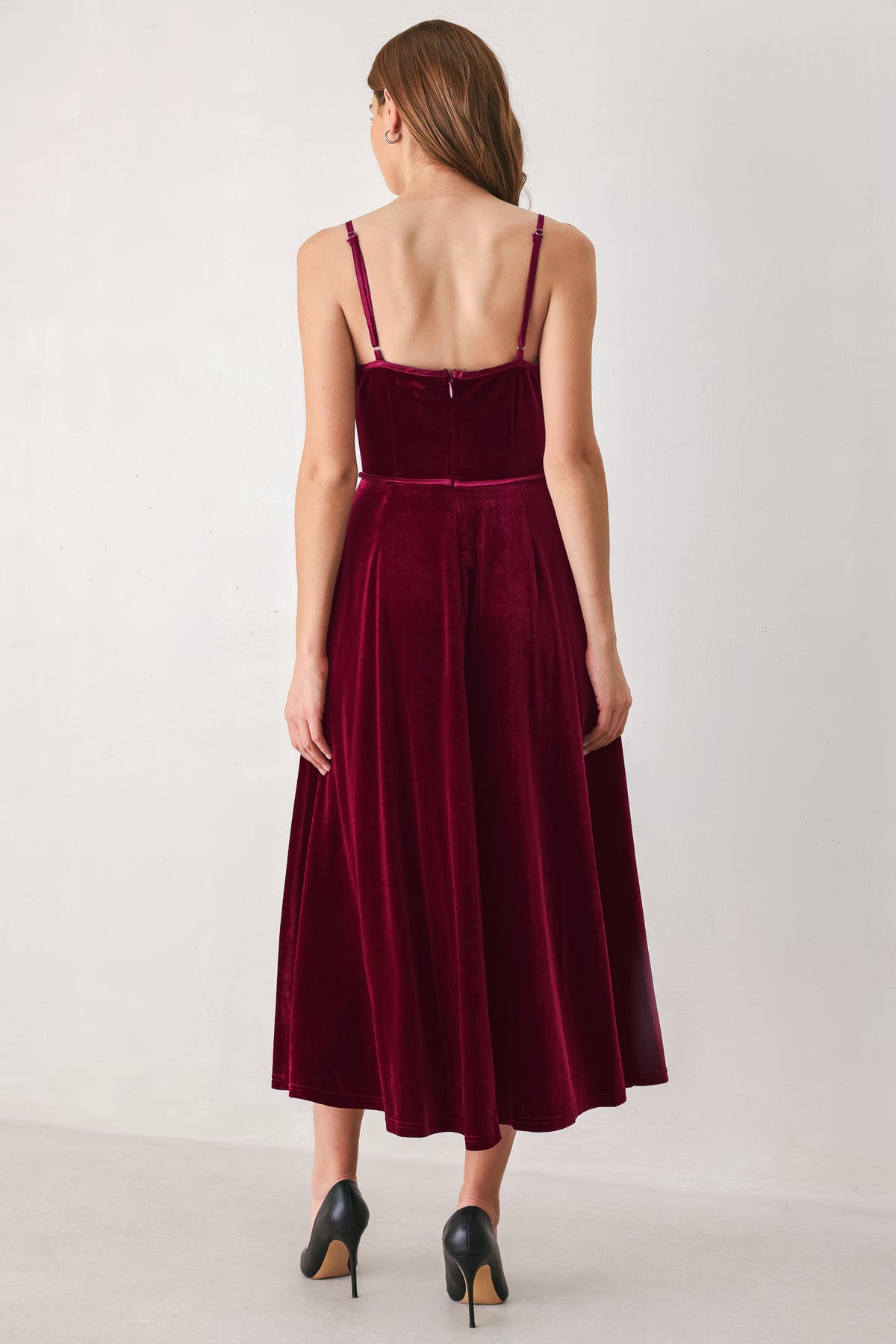 Woman wearing a sleeveless red burgundy velvet midi dress with a slight plunge | FREEMARKET