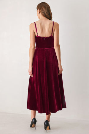 Woman wearing a sleeveless red burgundy velvet midi dress with a slight plunge | FREEMARKET