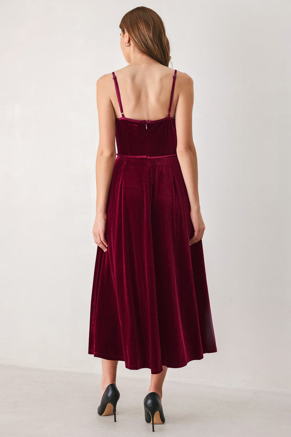 Woman wearing a sleeveless red burgundy velvet midi dress with a slight plunge | FREEMARKET