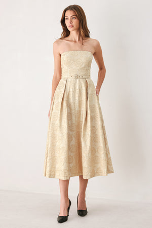 Woman wearing a strapless gold jacquard floral midi dress with a matching waist belt | FREEMARKET