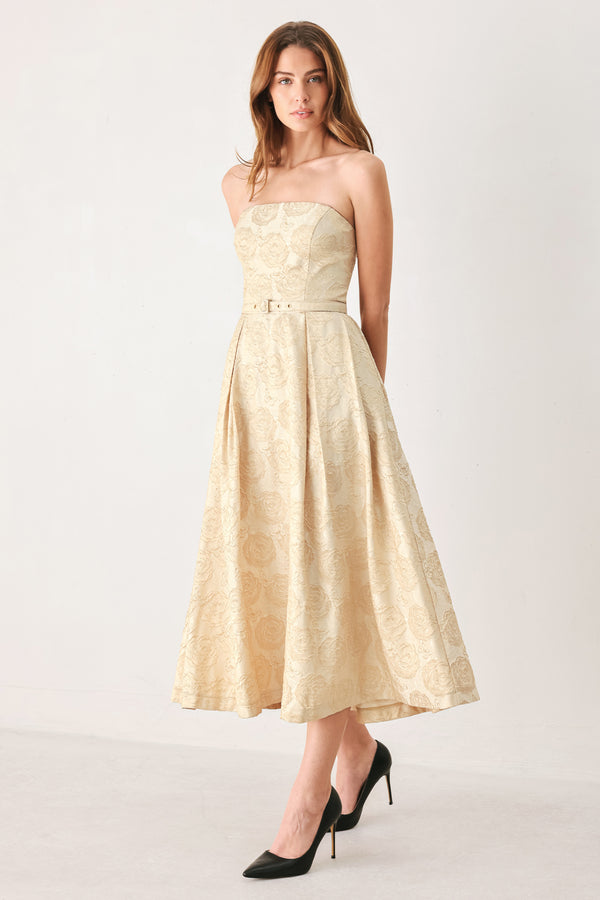 Woman wearing a strapless gold jacquard floral midi dress with a matching waist belt | FREEMARKET