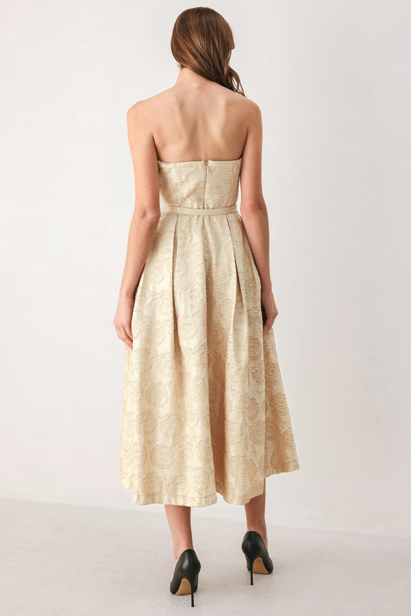 Woman wearing a strapless gold jacquard floral midi dress with a matching waist belt | FREEMARKET
