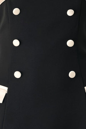 Woman wearing a strapless black midi dress with cream strap across the strapless neckline, double breasted buttons, faux pockets | FREEMARKET