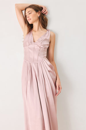 Woman wearing a pink satin sleeveless gown with structured boning on around the waist and pleated skirt | FREEMARKET