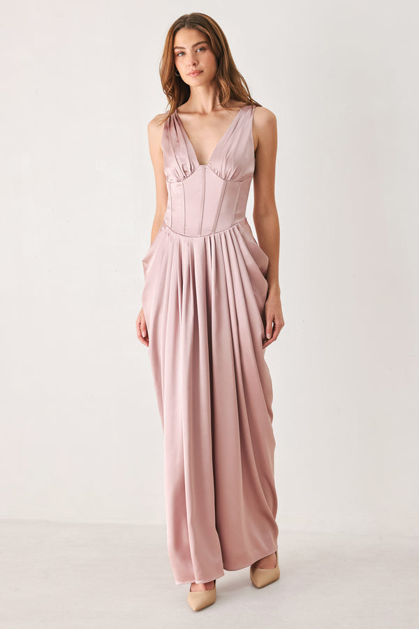 Woman wearing a pink satin sleeveless gown with structured boning on around the waist and pleated skirt | FREEMARKET