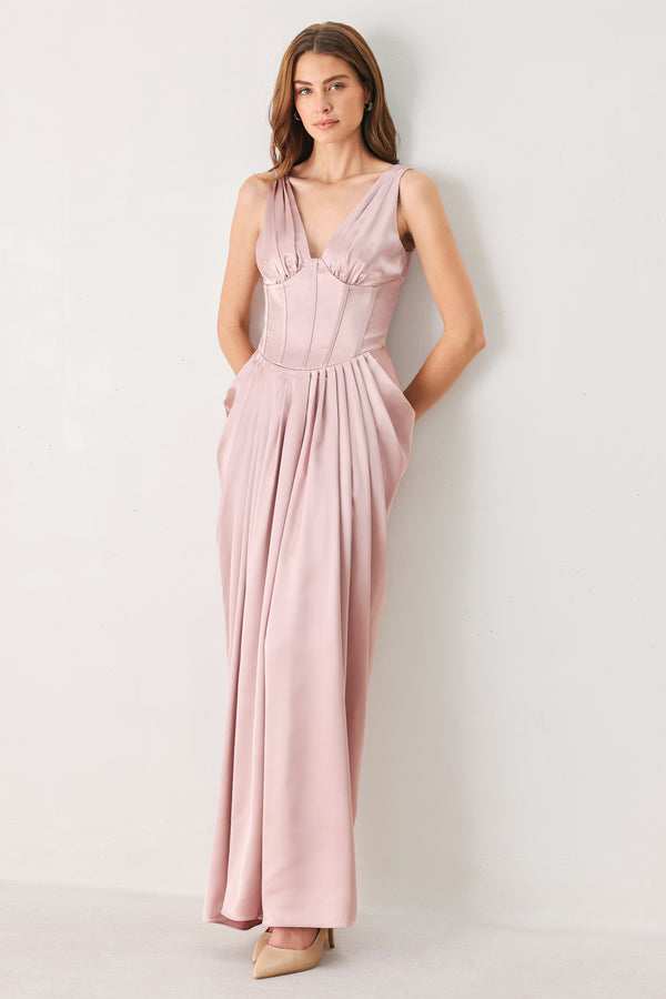 Woman wearing a pink satin sleeveless gown with structured boning on around the waist and pleated skirt | FREEMARKET