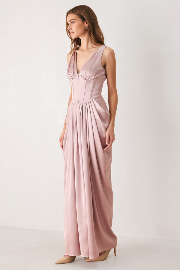 Woman wearing a pink satin sleeveless gown with structured boning on around the waist and pleated skirt | FREEMARKET