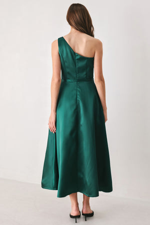 A woman models a sleeveless one-shoulder midi dress in emerald green satin, featuring a structured bodice, a thin waist belt, and a flared skirt | FREEMARKET