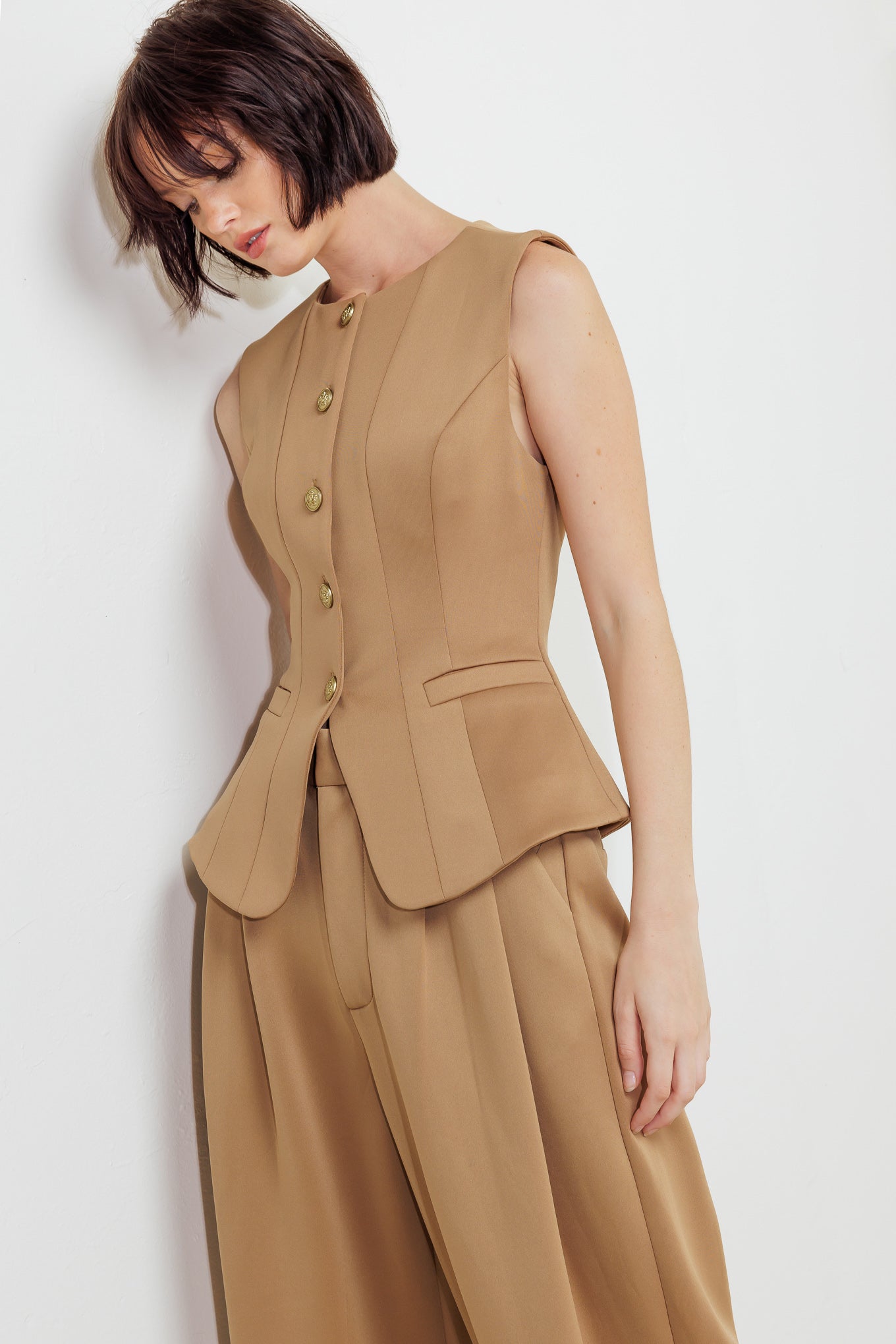 A solid woven vest featuring round neckline, sleeveless, front button down and pockets.