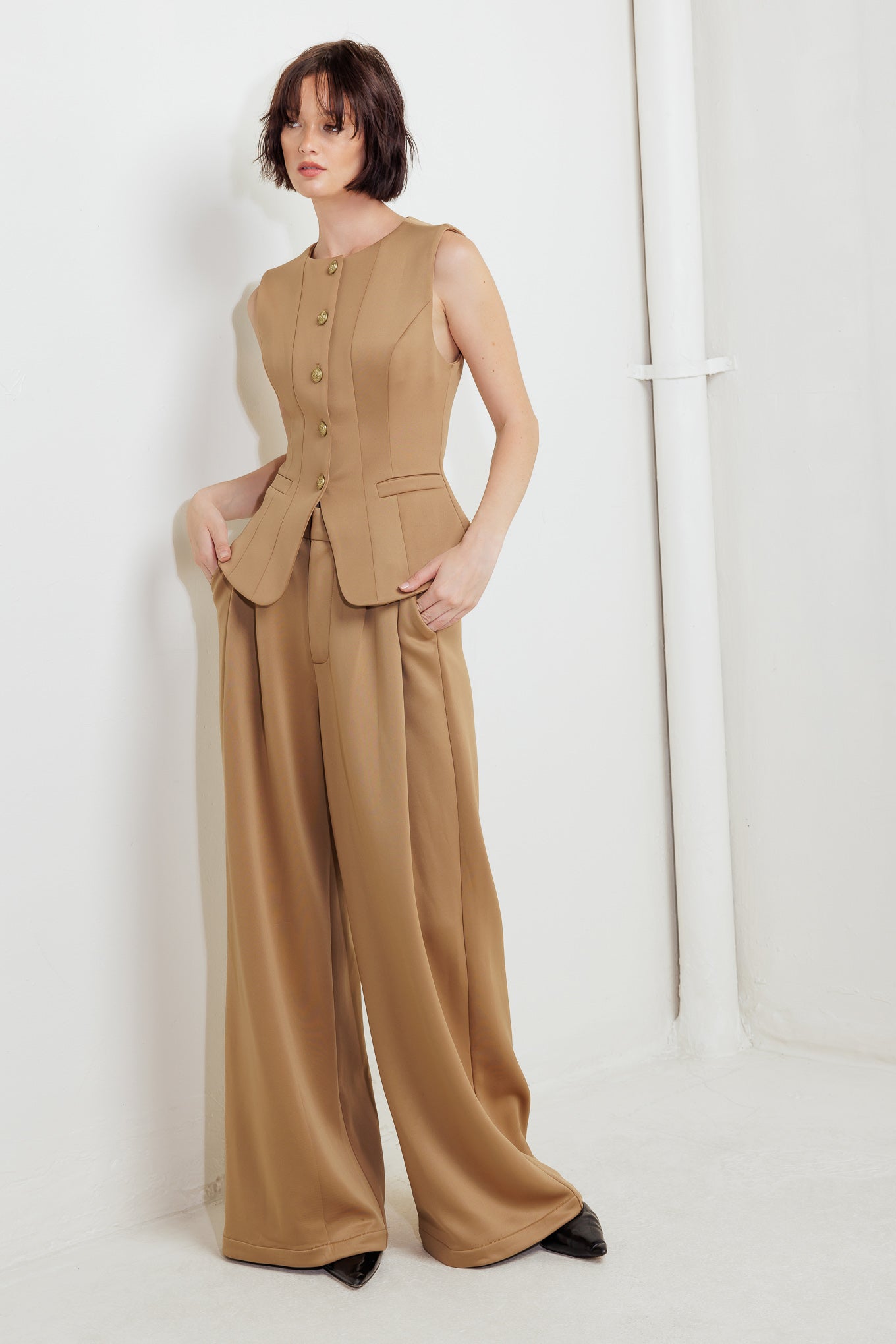 A solid woven vest featuring round neckline, sleeveless, front button down and pockets.