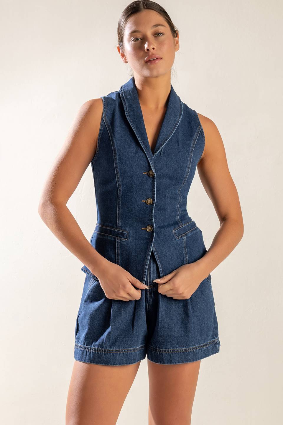 A washed denim vest featuring shawl collar, sleeveless and button down.