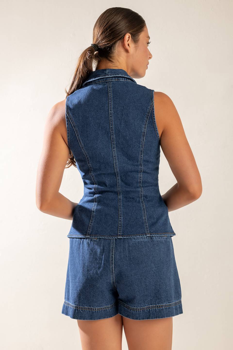 A washed denim vest featuring shawl collar, sleeveless and button down.