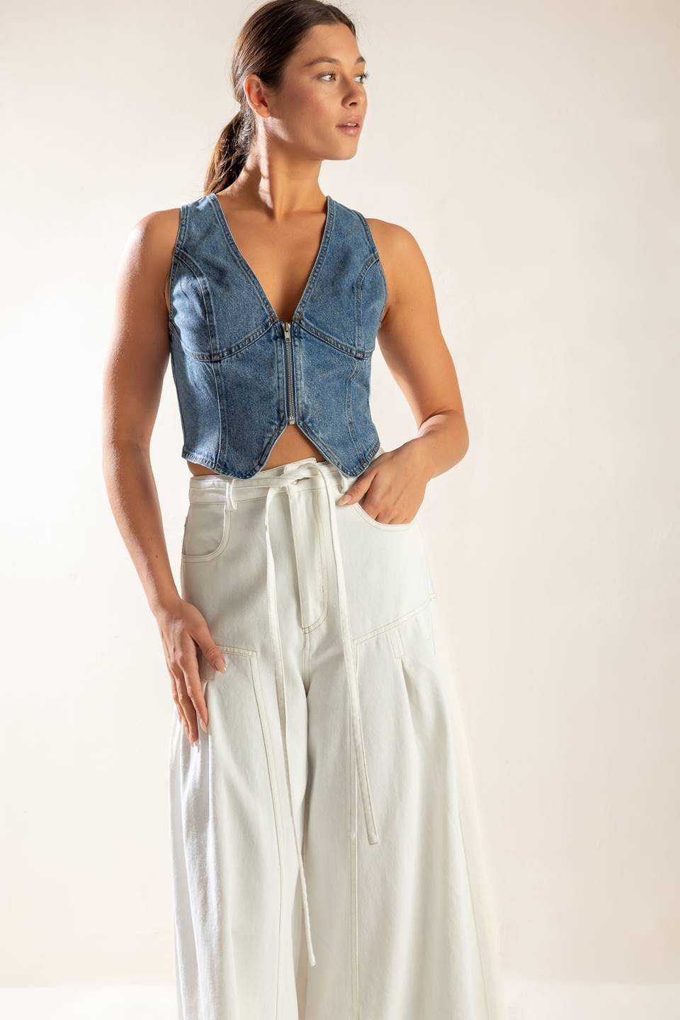 A washed denim vest featuring sleeveless and front zipper closure