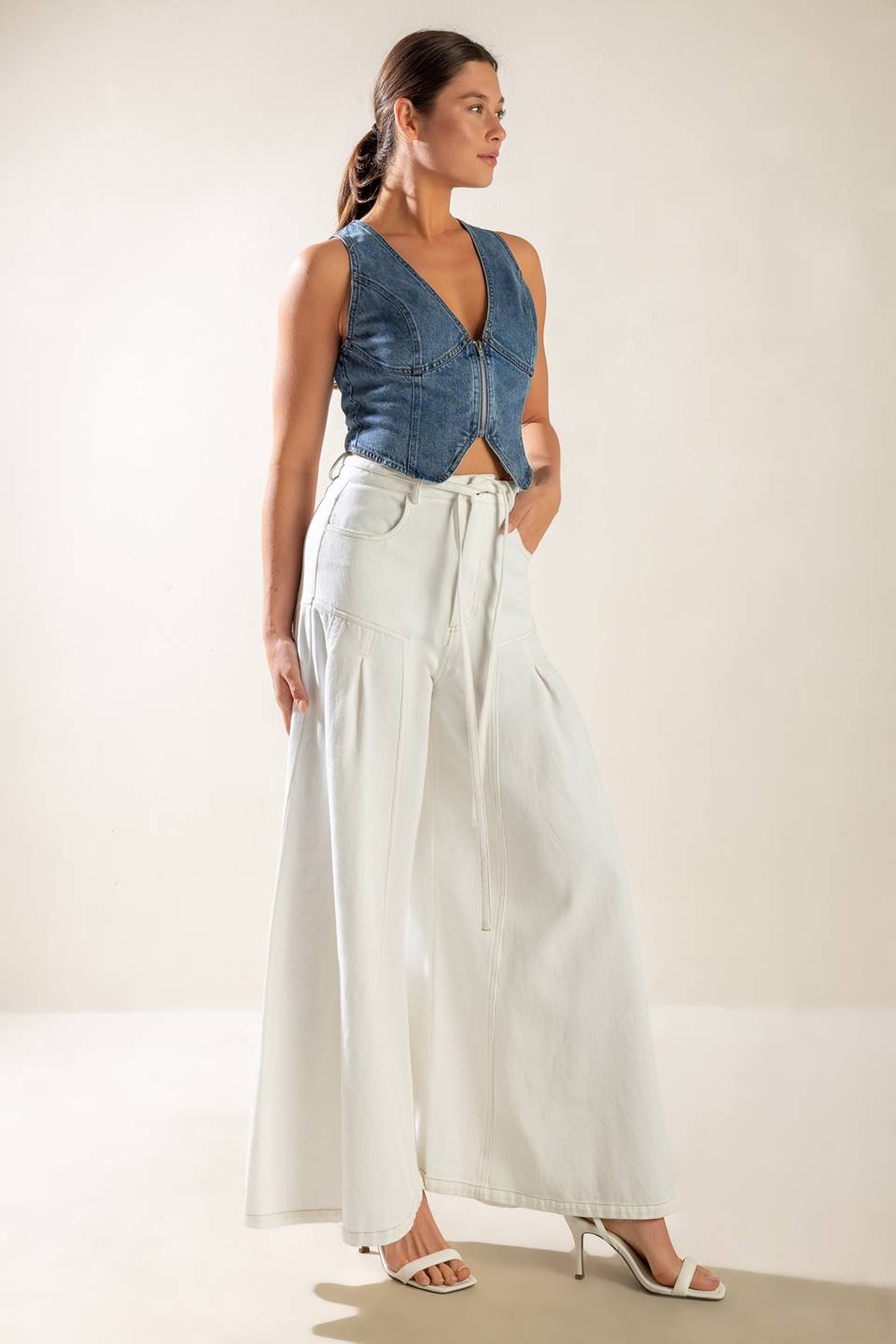 A washed denim vest featuring sleeveless and front zipper closure