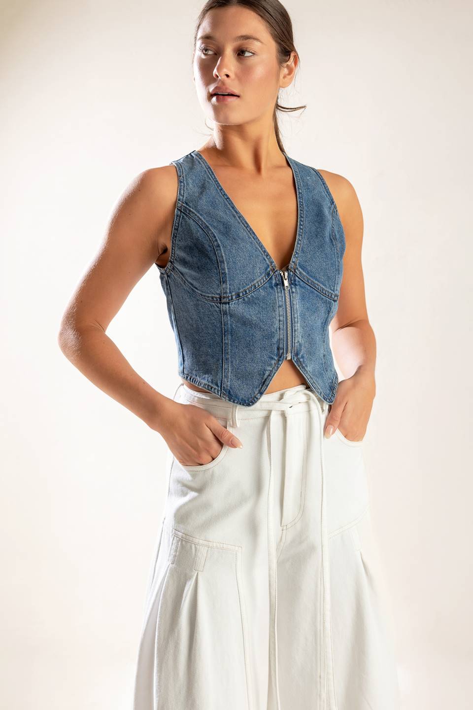 A washed denim vest featuring sleeveless and front zipper closure