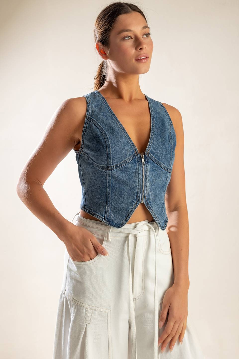 A washed denim vest featuring sleeveless and front zipper closure