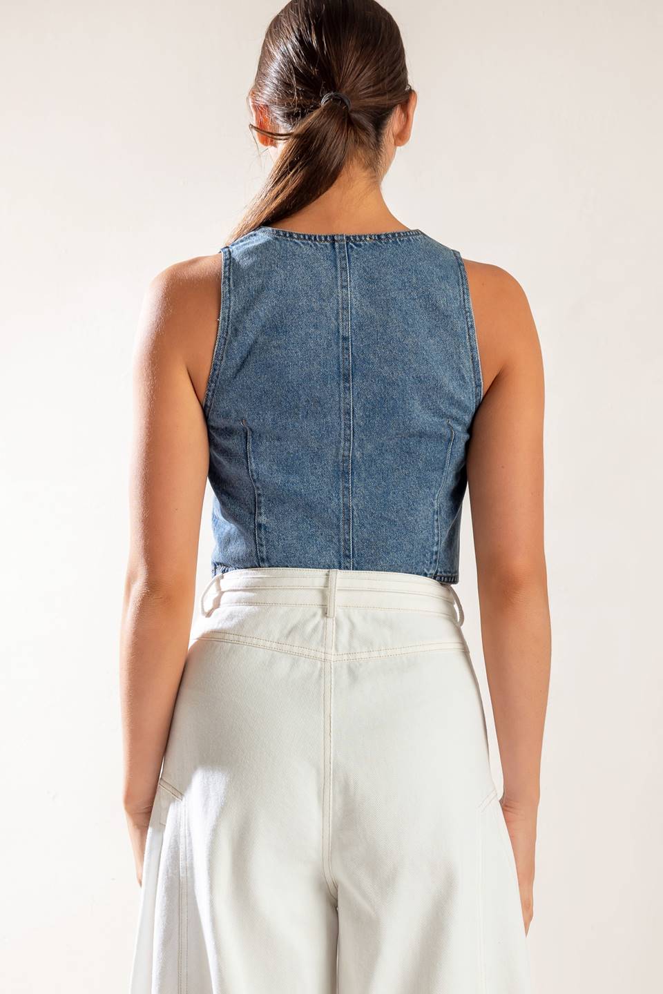 A washed denim vest featuring sleeveless and front zipper closure