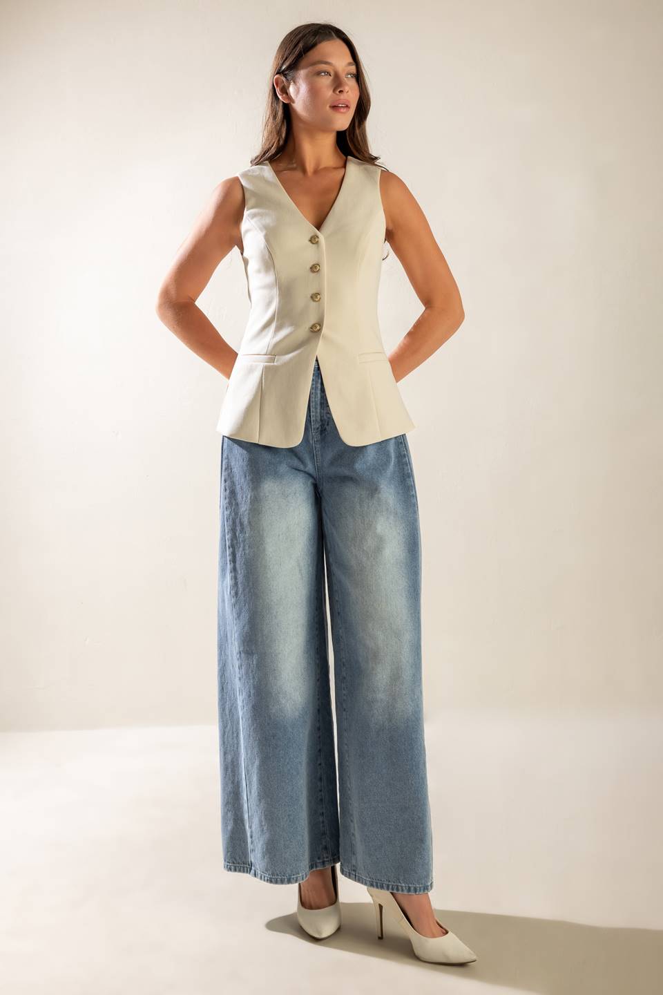 A sleeveless solid woven vest featuring V neckline, button down and back slit.