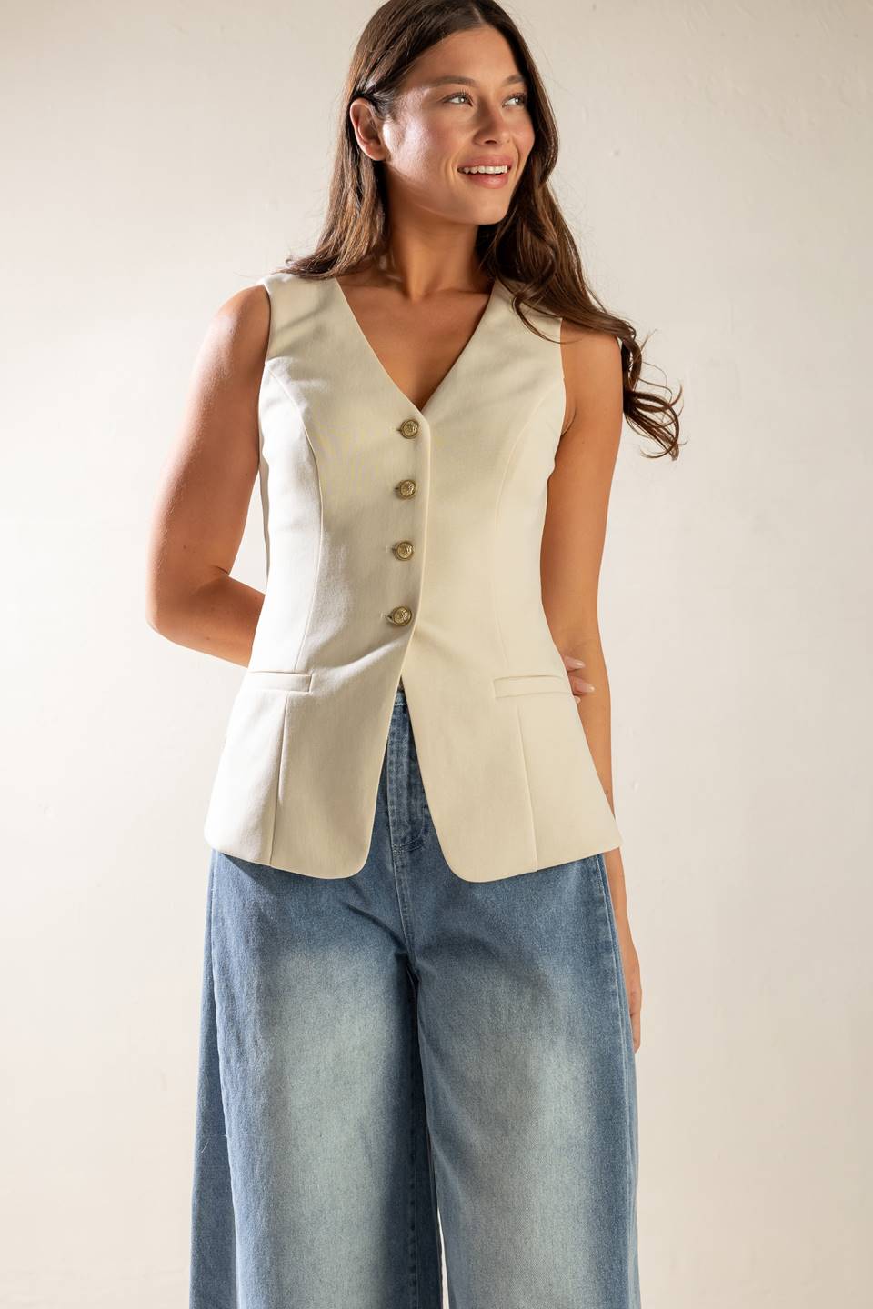 A sleeveless solid woven vest featuring V neckline, button down and back slit.