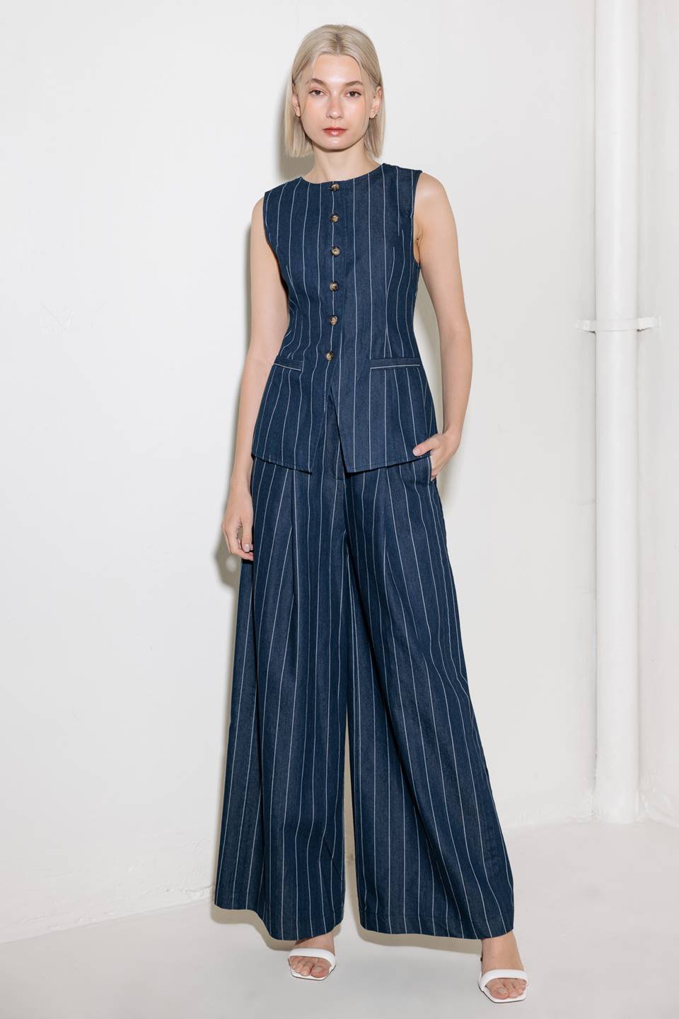 A striped woven vest featuring round neckline, sleeveless and button down.