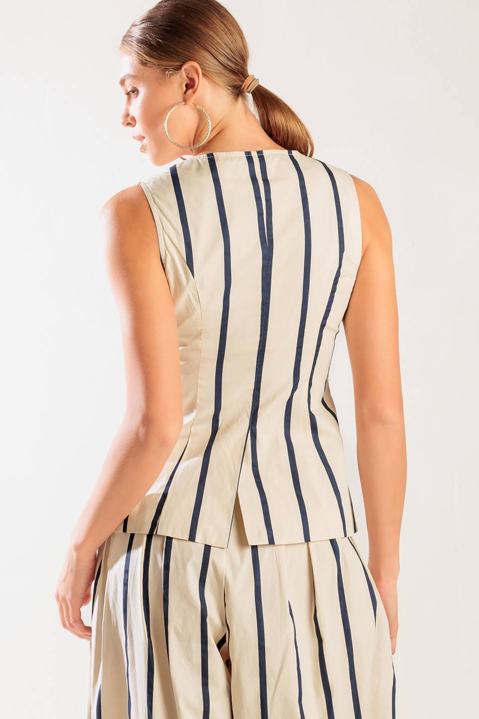 A striped woven vest featuring round neckline, sleeveless and button down.