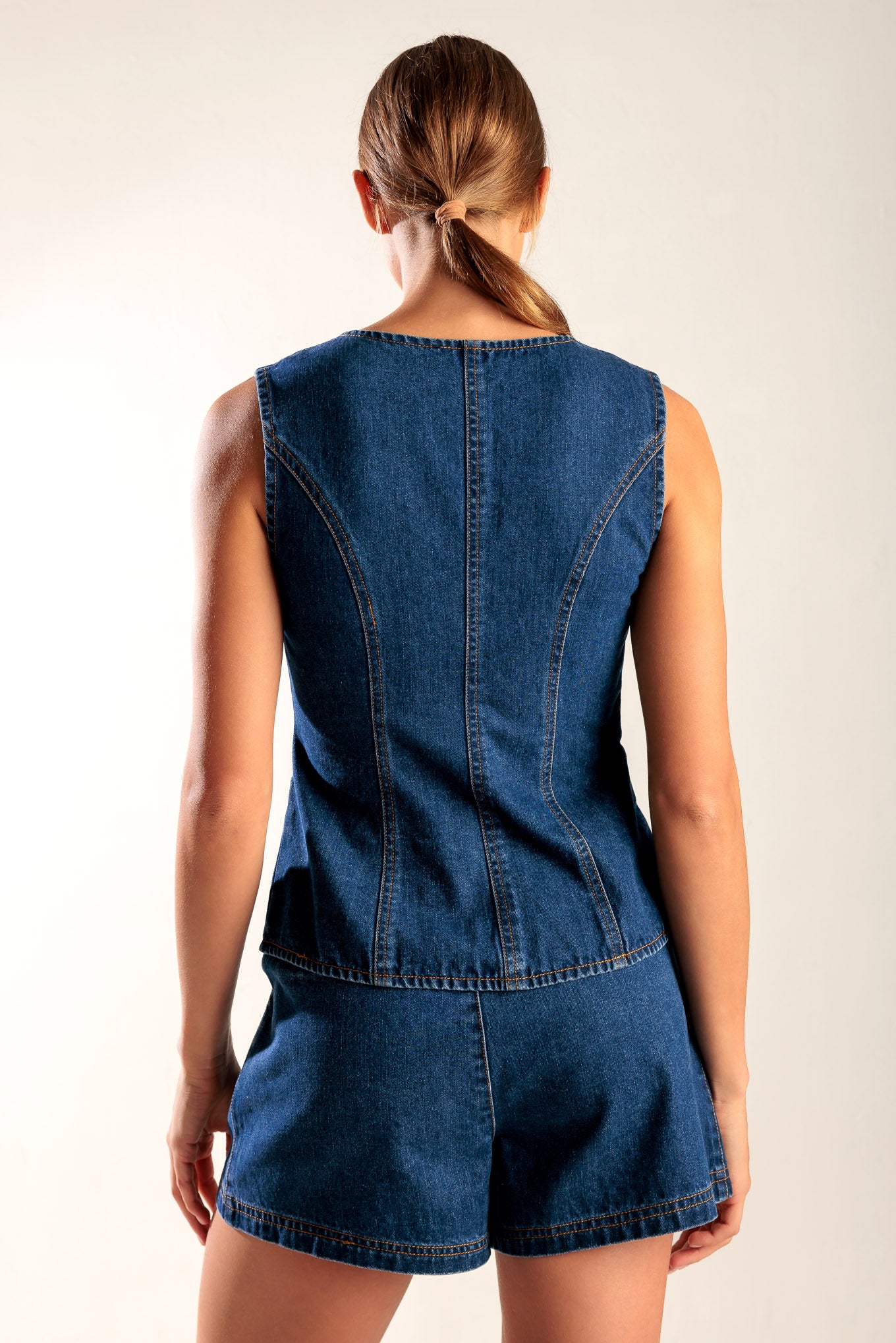 A denim vest featuring round neckline, sleeveless and front button closure.