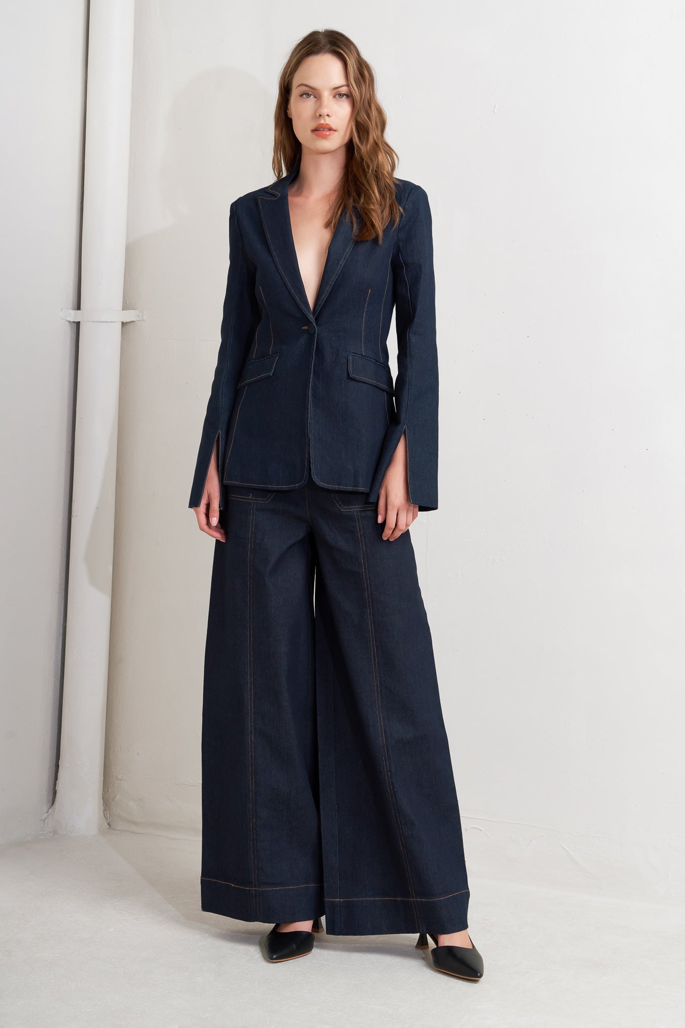 A denim blazer with single button closure and slit at sleeve