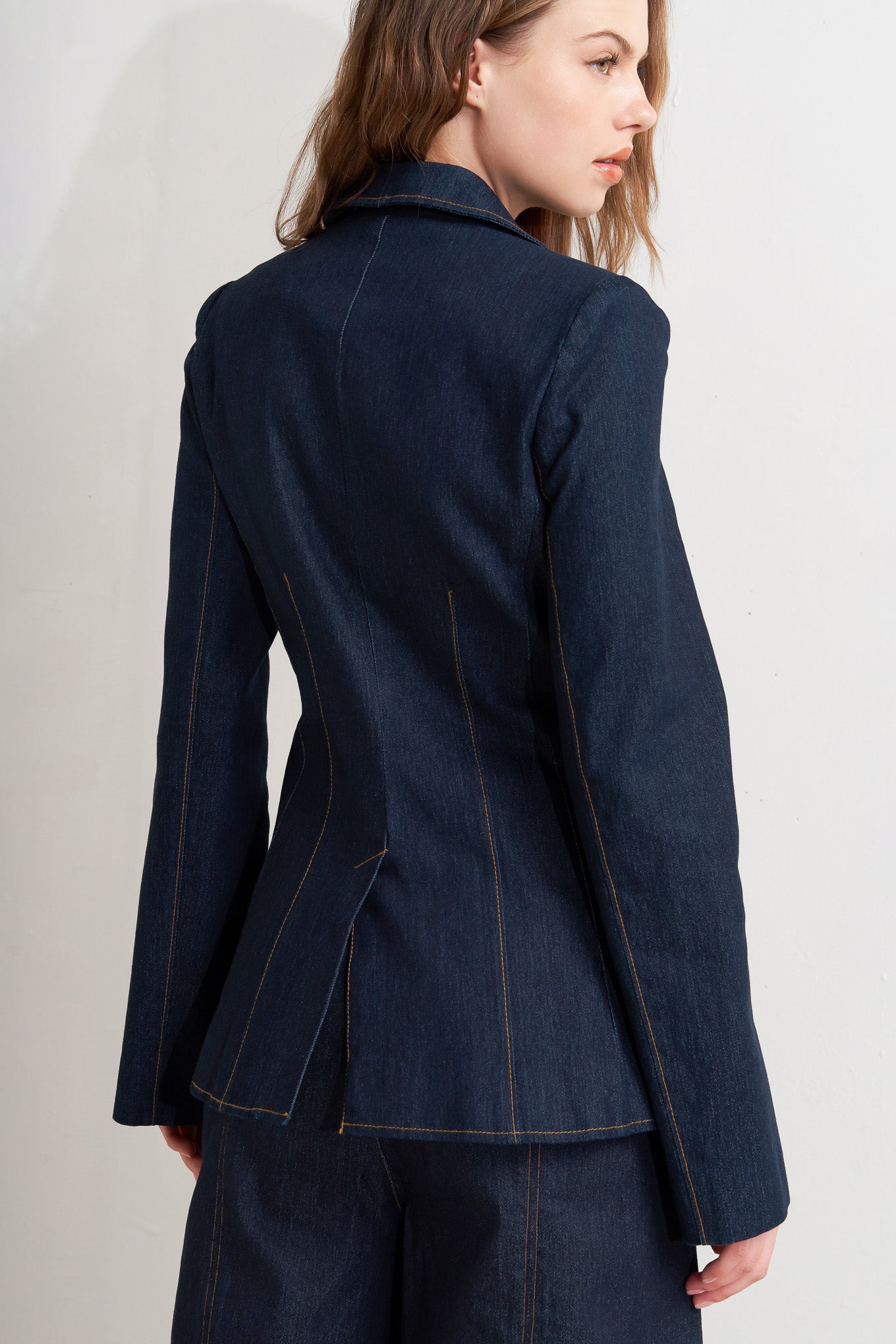 A denim blazer with single button closure and slit at sleeve