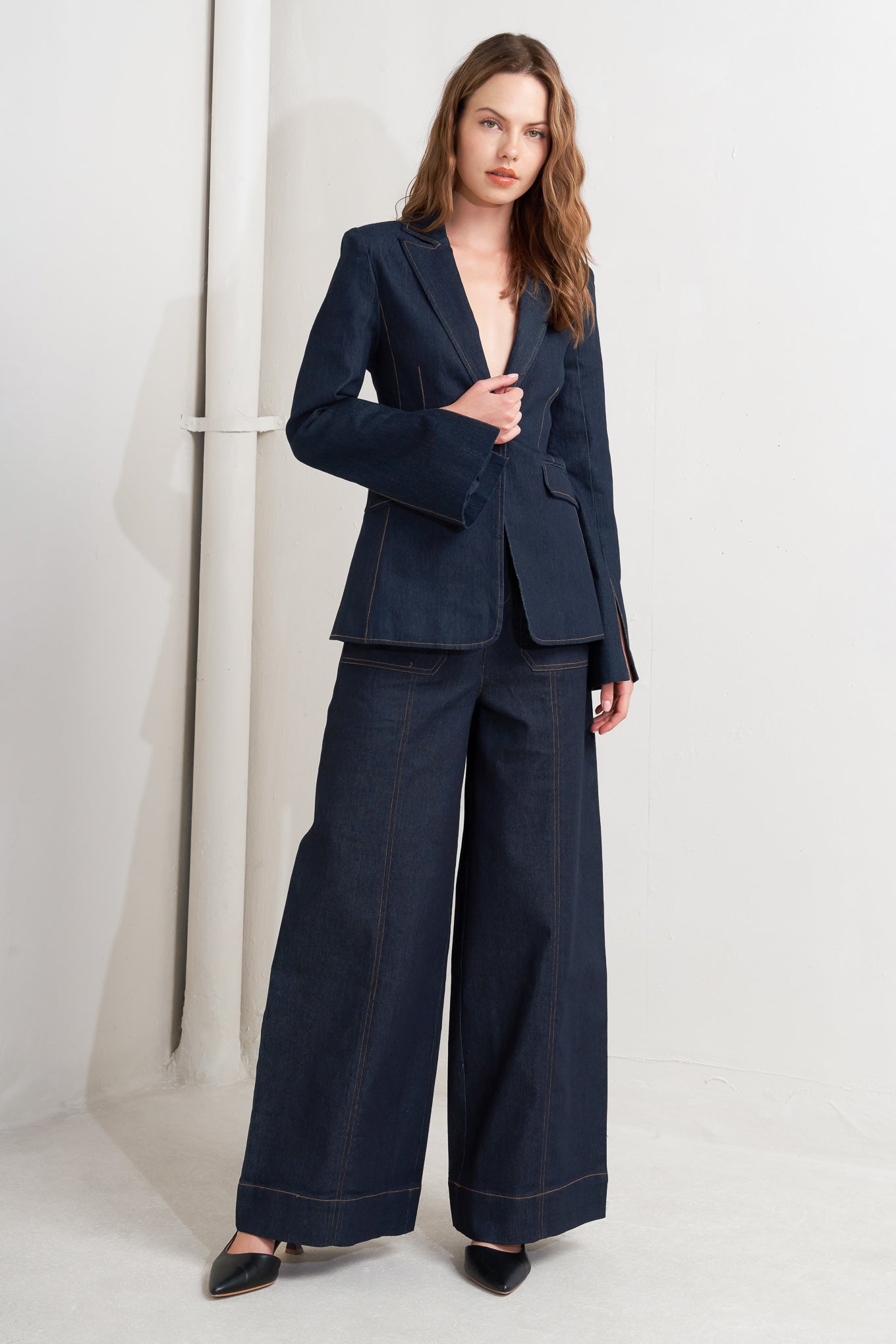 A denim blazer with single button closure and slit at sleeve