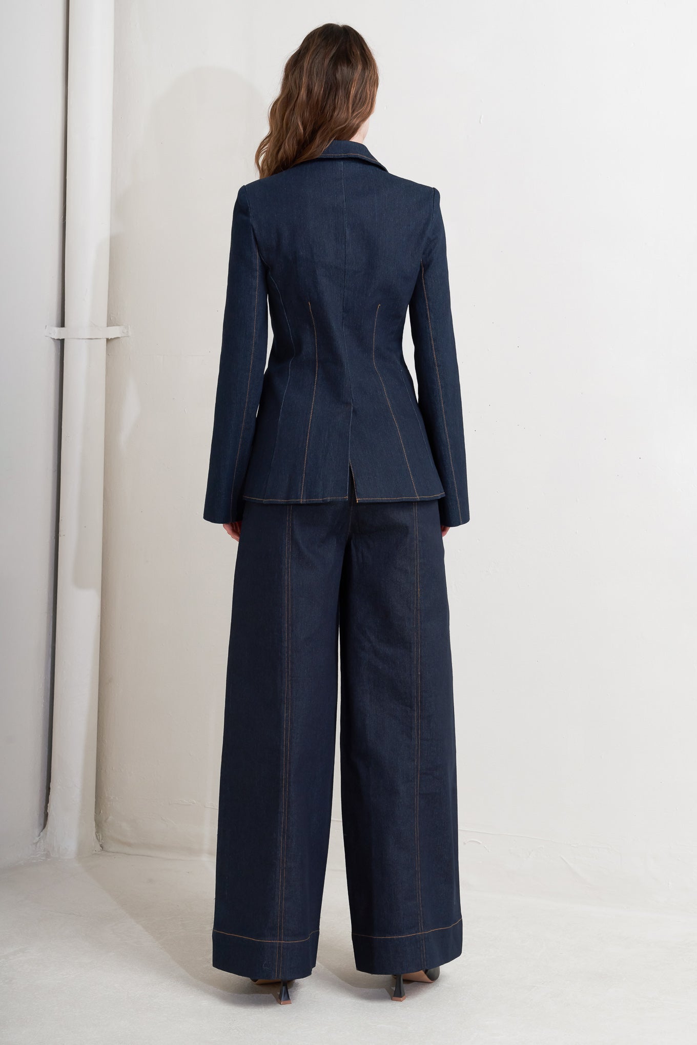 A denim blazer with single button closure and slit at sleeve