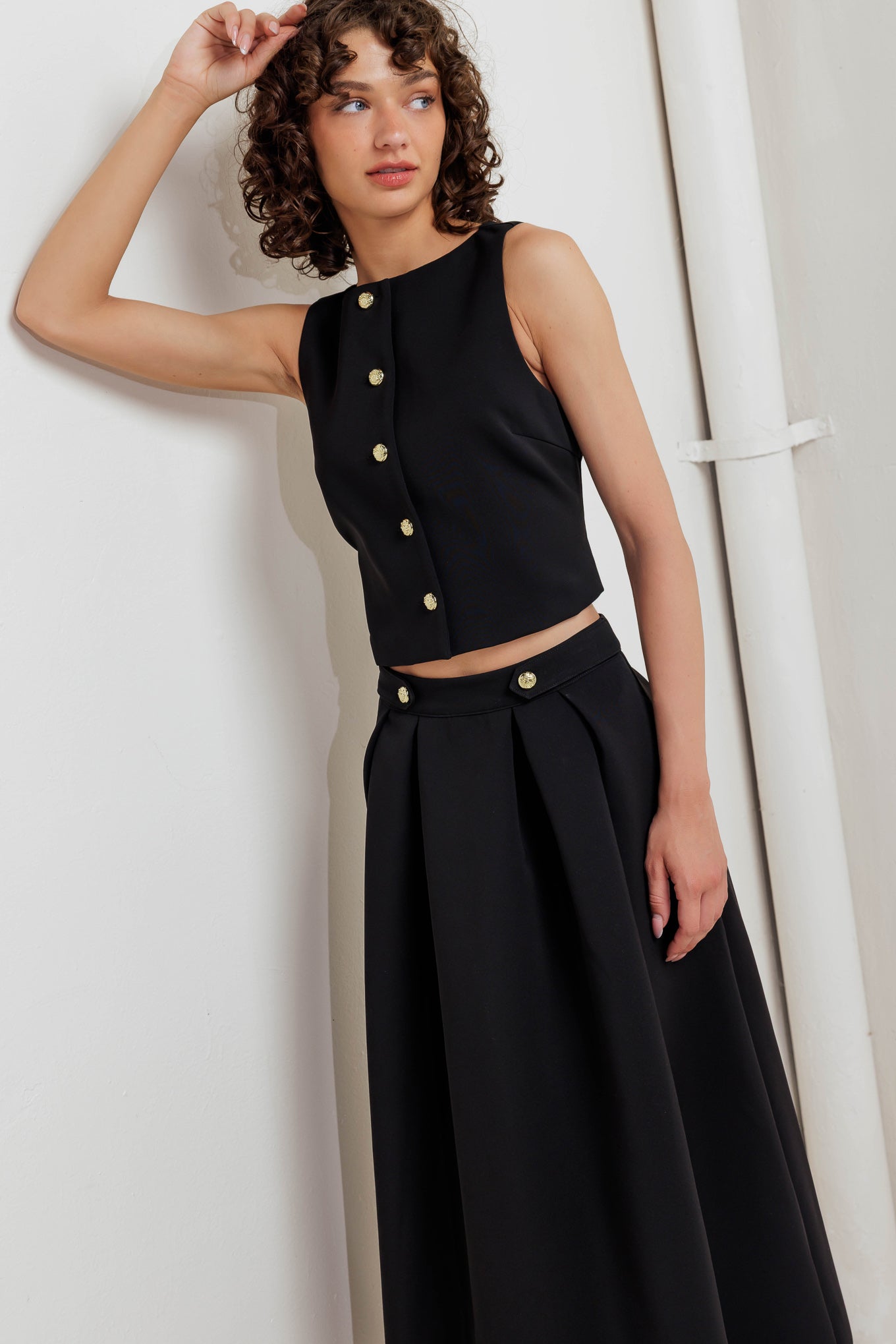 A solid woven vest with front button closure.
