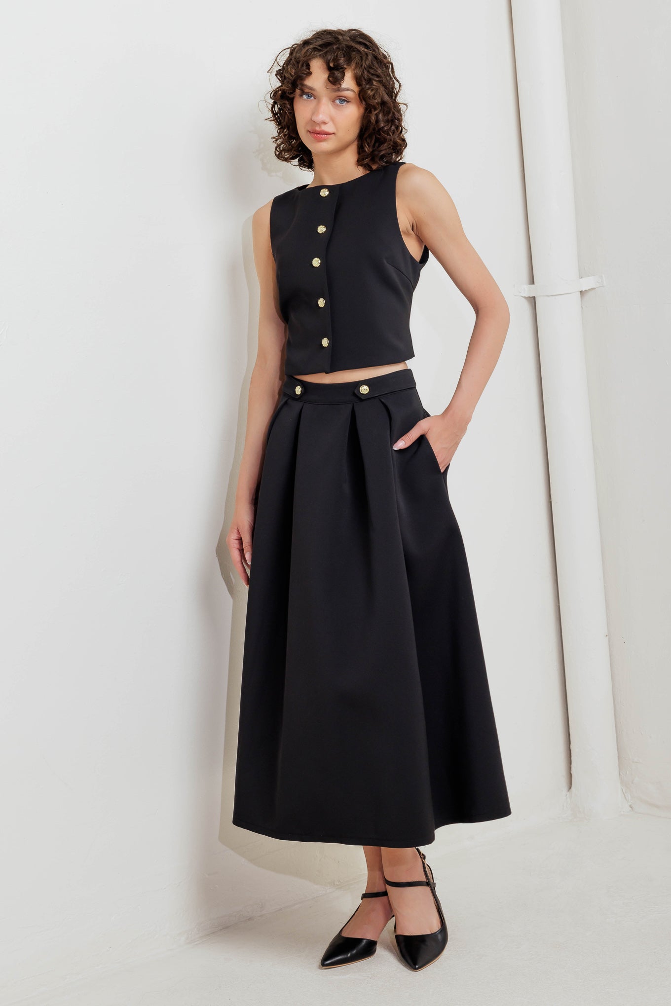 A solid woven vest with front button closure.