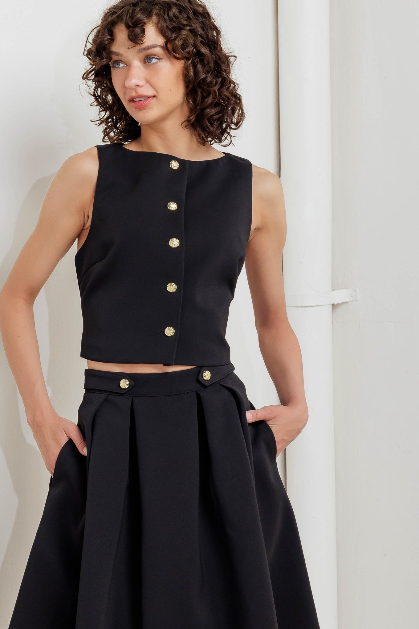 A solid woven vest with front button closure.