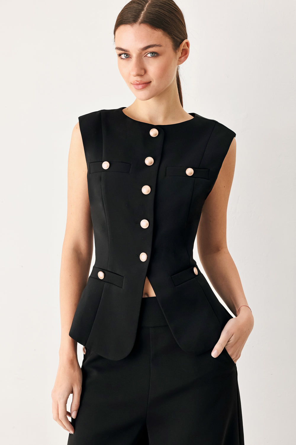 Woman wearing a black sleeveless blazer vest with gold buttons | FREEMARKET