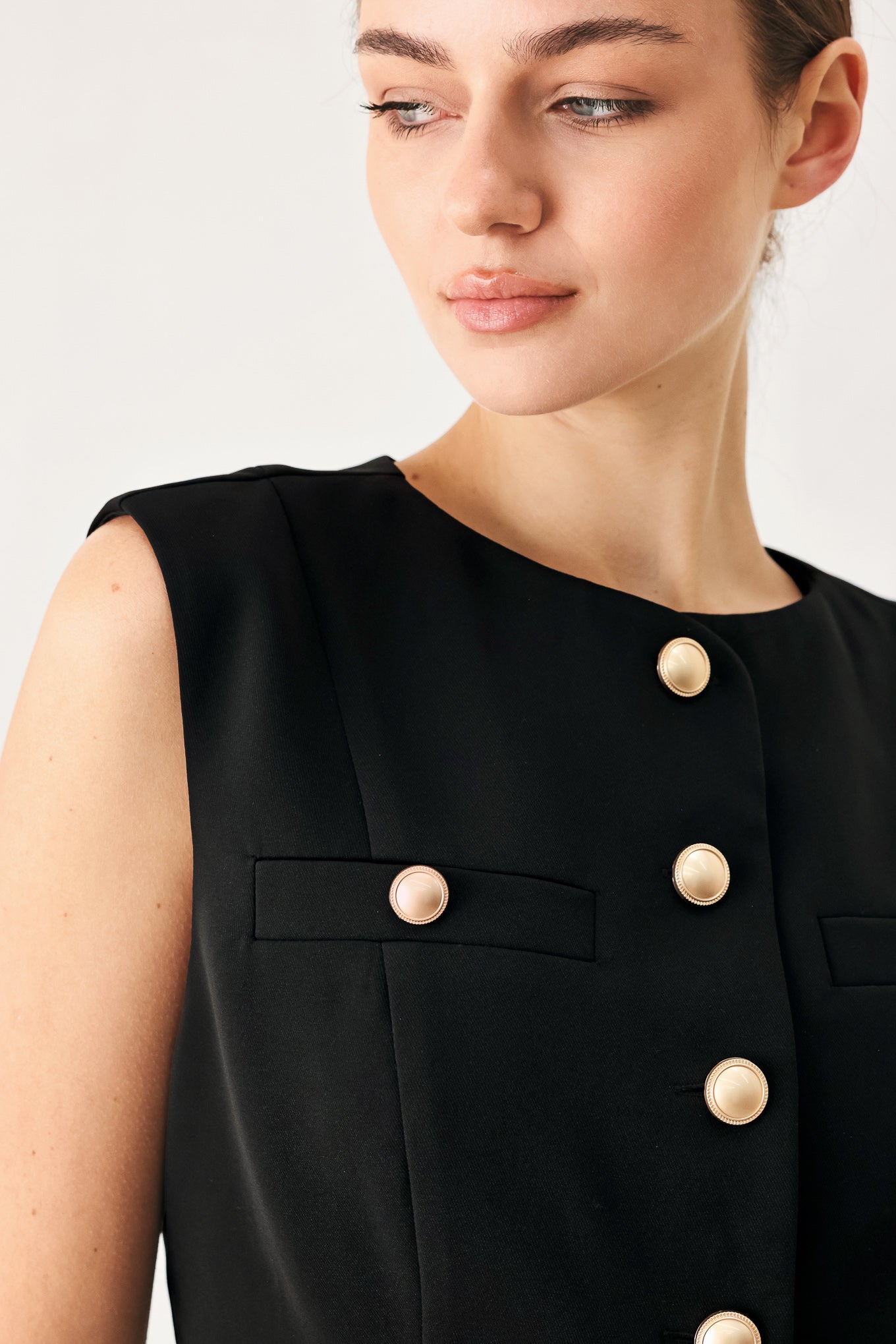 Woman wearing a black sleeveless blazer vest with gold buttons | FREEMARKET