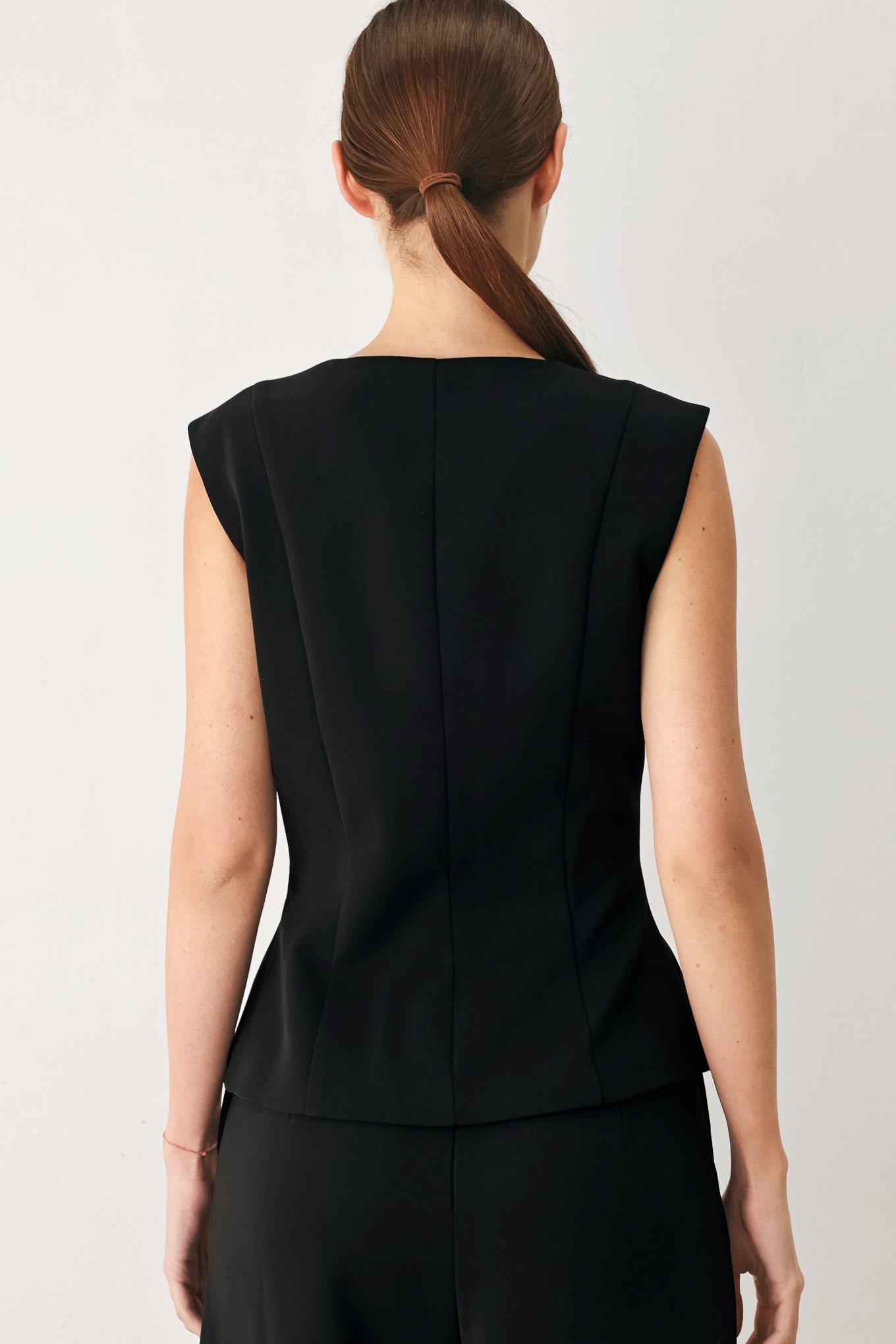 Woman wearing a black sleeveless blazer vest with gold buttons | FREEMARKET