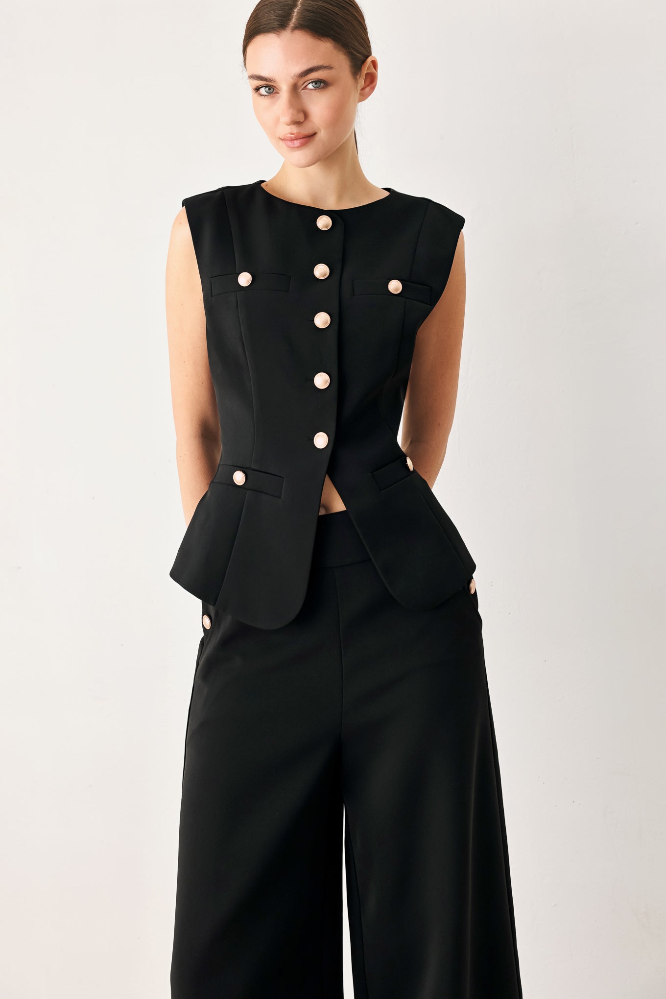 Woman wearing a black sleeveless blazer vest with gold buttons | FREEMARKET