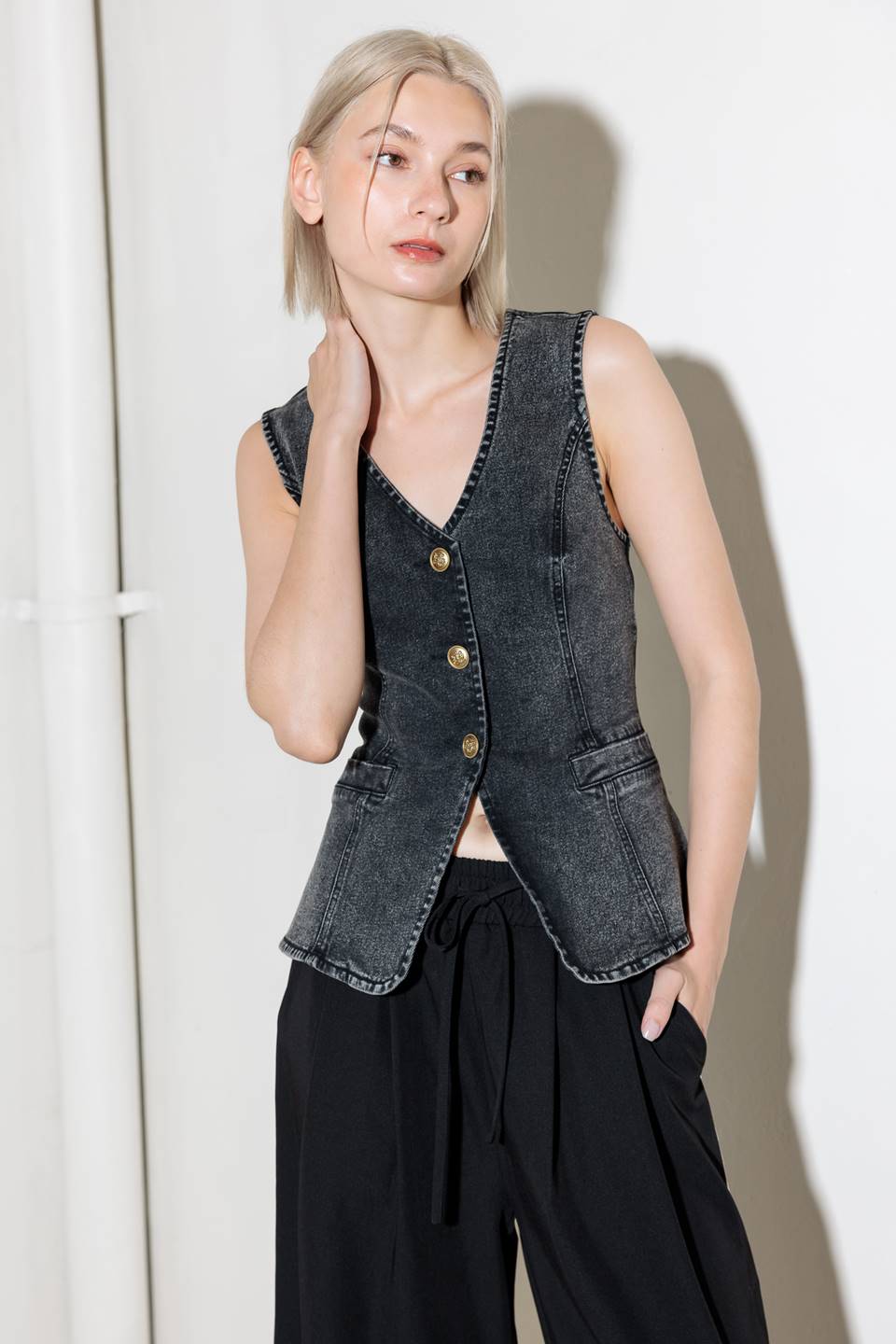 A washed denim vest with V neckline and front closure.