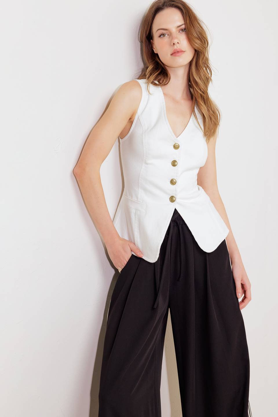 A solid white woven vest featuring V neckline, sleeveless and front button closure