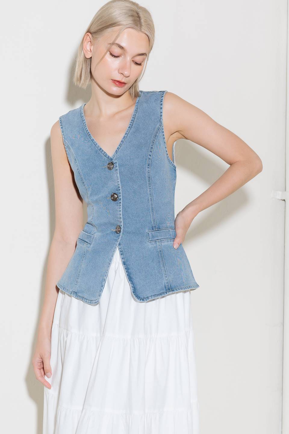 A washed denim vest with V neckline and front closure.