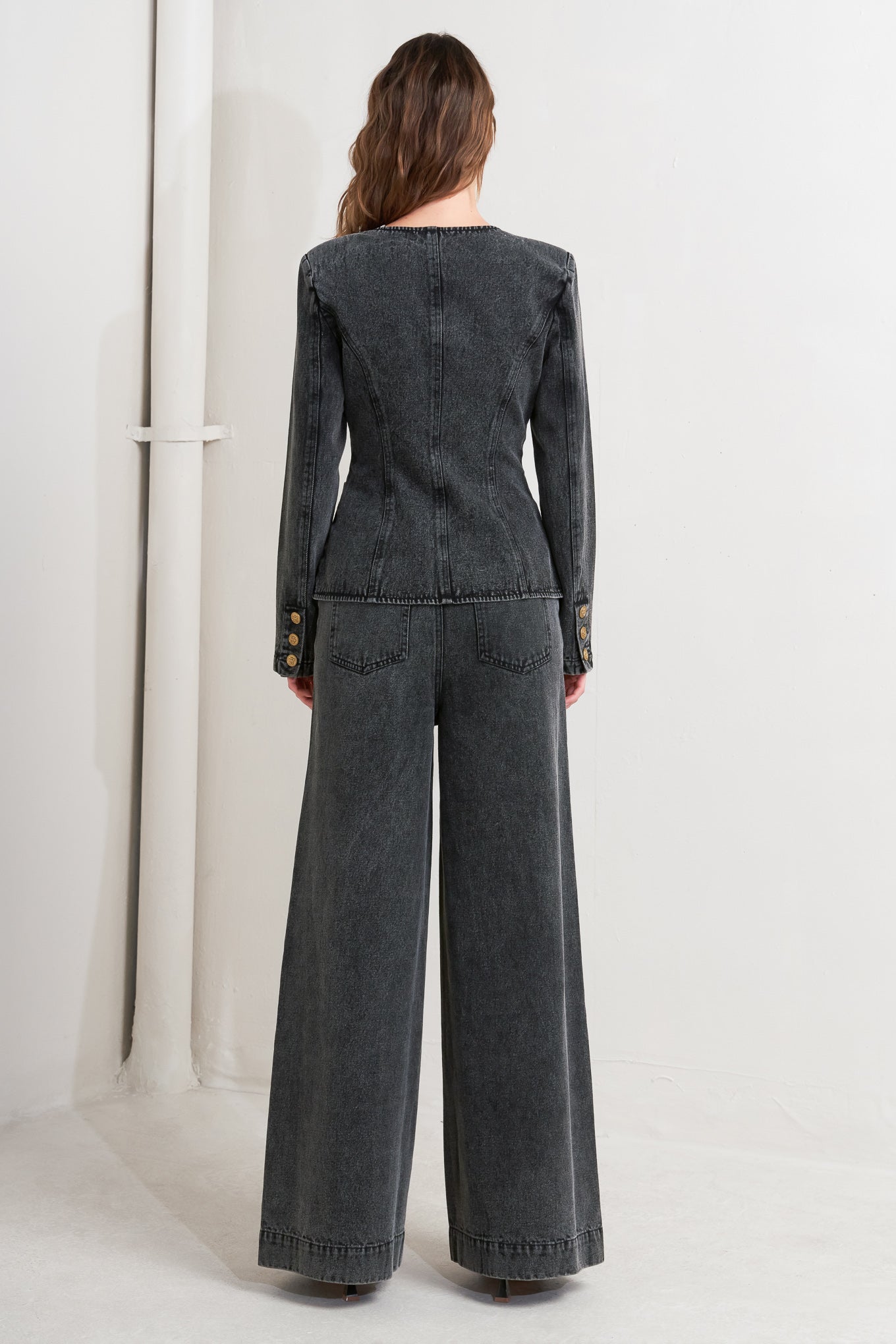 A washed denim jacket featuring round neckline and front button closure with pockets.