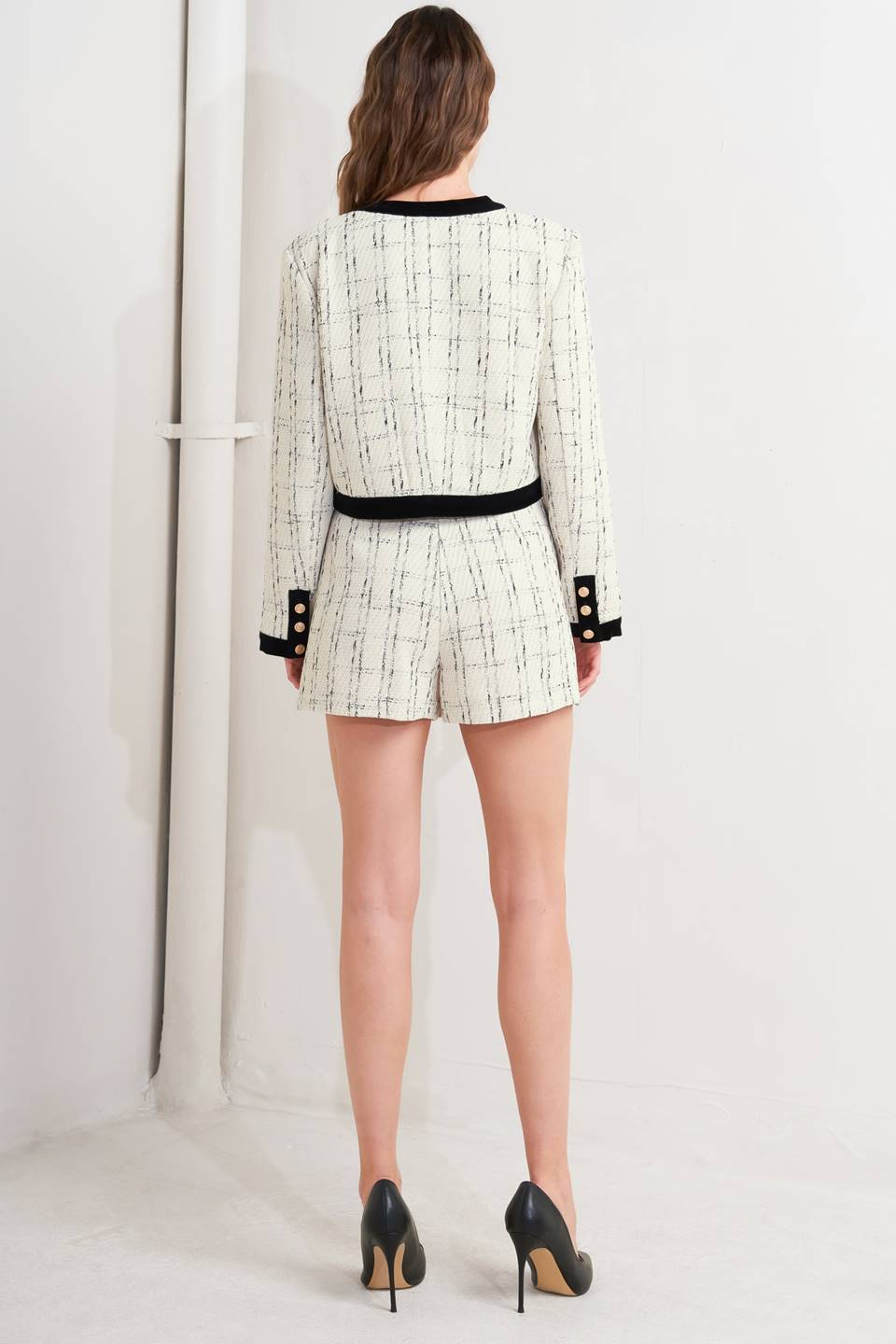 A woven tweed crop jacket featuring round neckline, long sleeve, contrasting hem and front button closure