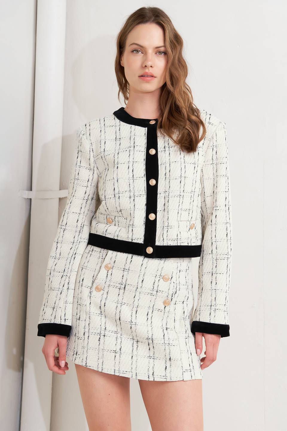 A woven tweed crop jacket featuring round neckline, long sleeve, contrasting hem and front button closure