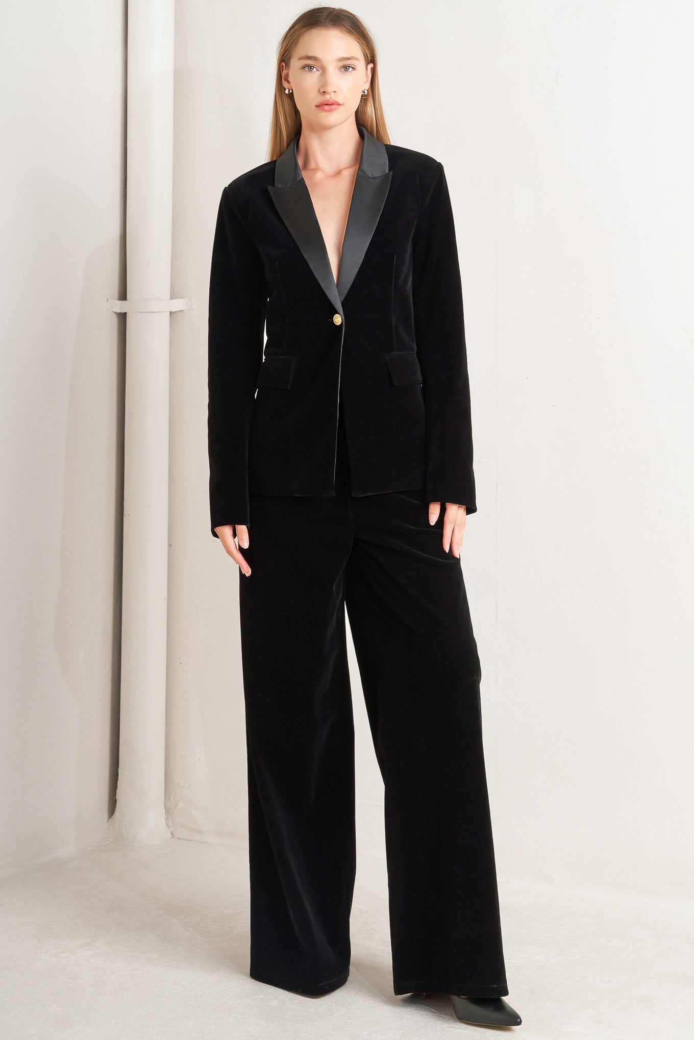A bonded woven velvet blazer with satin collar and front single button closure.