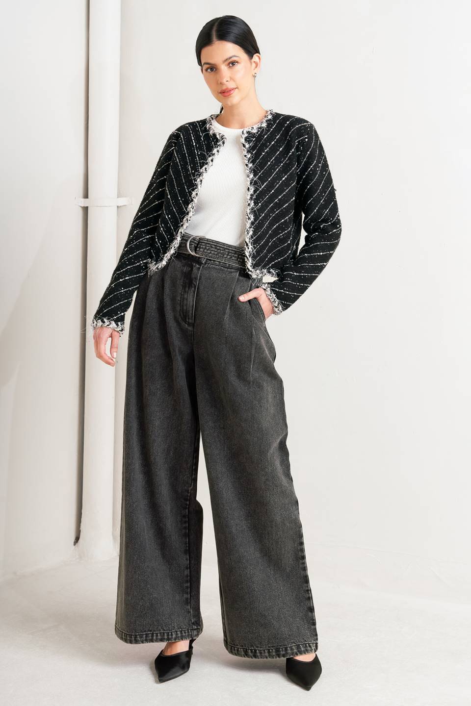 Woman wearing a black and white patterned jacket and wide-leg jeans on a white background, A sweater knit cropped jacket featuring round neckline, contrasting edge and front hook &amp; eye closure - FLYING TOMATO