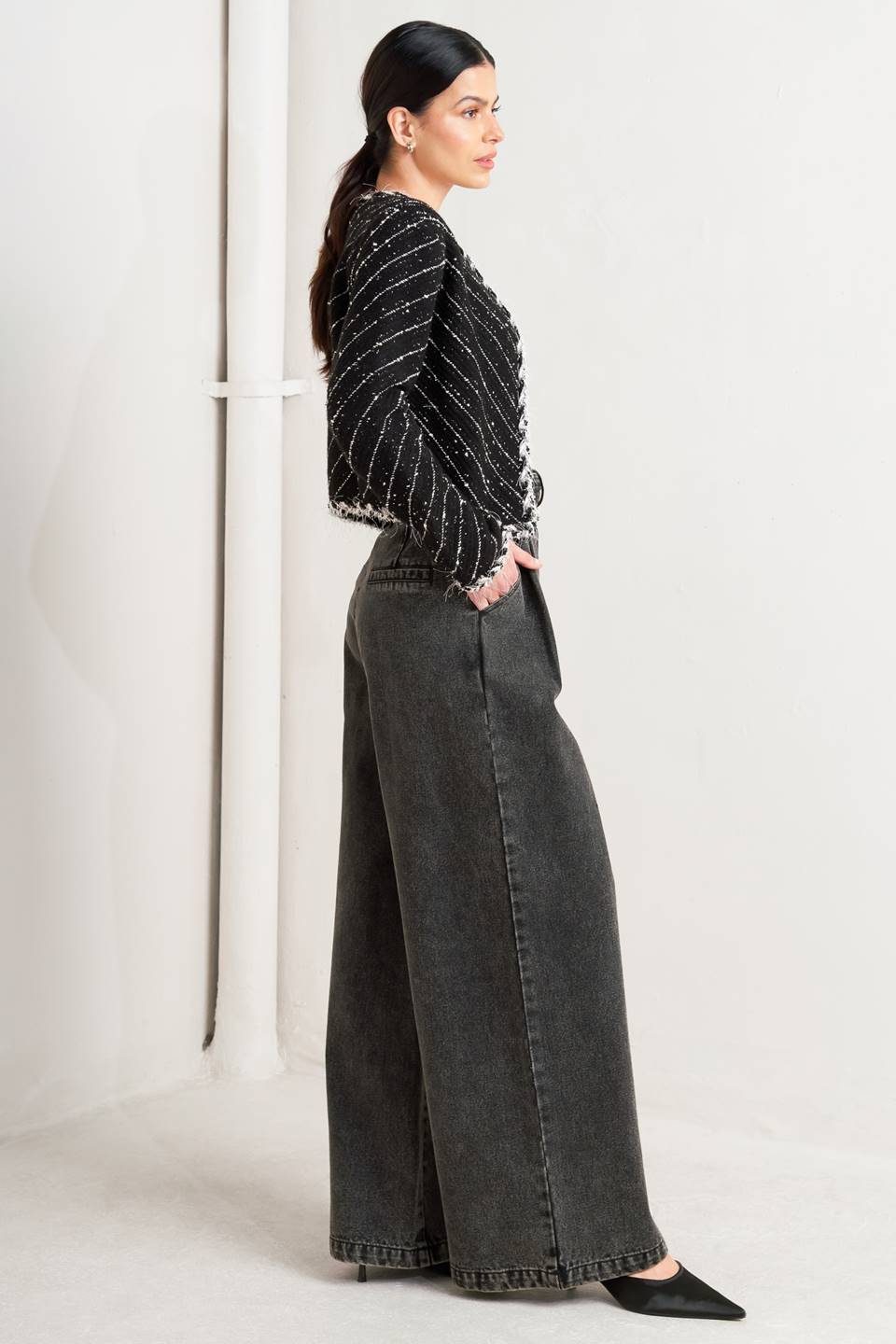 Woman wearing a black and white patterned jacket and wide-leg jeans on a white background, A sweater knit cropped jacket featuring round neckline, contrasting edge and front hook &amp; eye closure - FLYING TOMATO