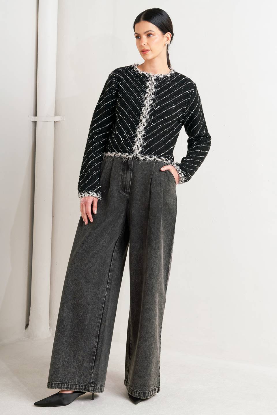 Woman wearing a black and white patterned jacket and wide-leg jeans on a white background, A sweater knit cropped jacket featuring round neckline, contrasting edge and front hook &amp; eye closure - FLYING TOMATO