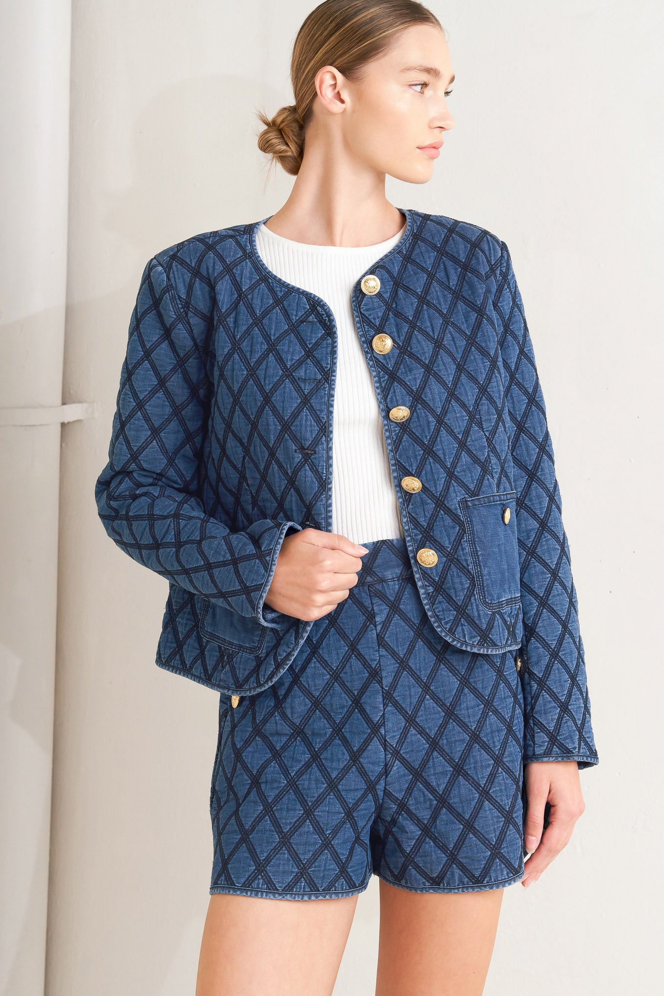 A quilted woven jacket featuring round neckline, long sleeve and front button down.